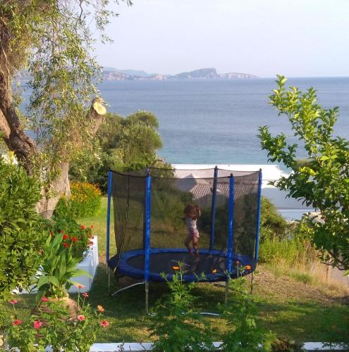 a little girl is playing on a trampoline at Elina Apartments in Parga