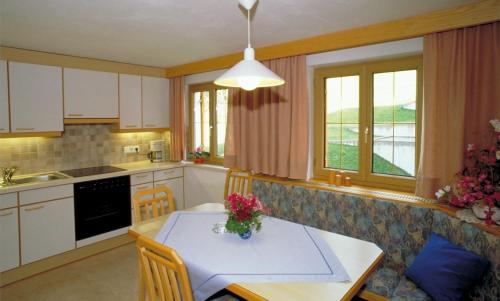 a kitchen with a table with a vase of flowers on it at Appart Fernblick in Gaschurn