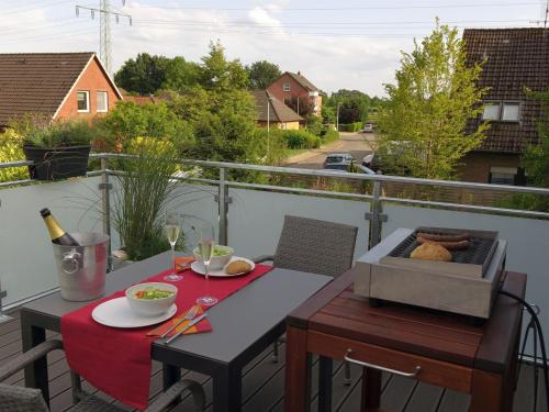 a table on a balcony with a bottle of wine at Ferienwohnung Tulpenweg in Bad Zwischenahn