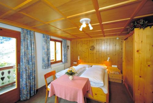 ein Schlafzimmer mit einem Bett und einem Tisch darin in der Unterkunft Appart Fernblick in Gaschurn