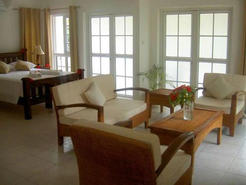 Bord Mer Villa في بو فالون: غرفة معيشة مع أريكة وكراسي وطاولة