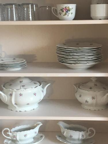 a shelf filled with plates and cups and dishes at Apartmenthaus Lütt Meer in Ludorf