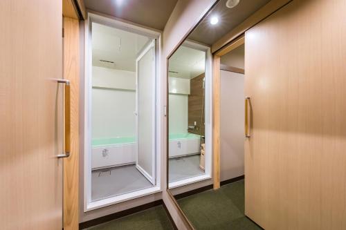 a bathroom with a walk in shower and a mirror at Akasaka Yoko Hotel in Tokyo