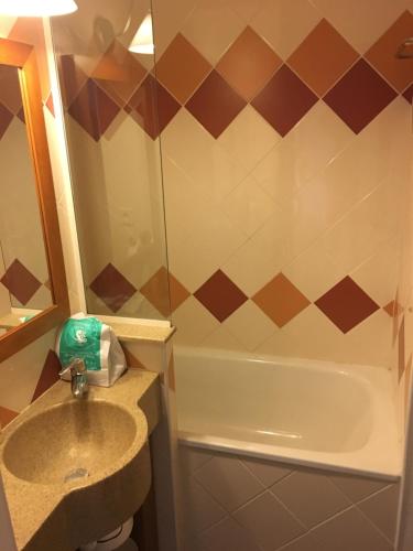 La salle de bains est pourvue d'un lavabo et d'une baignoire. dans l'établissement Appartement 5 pers Résidence Les Mélèzes quartier les Bergers Alpe d Huez, à L'Alpe-d'Huez