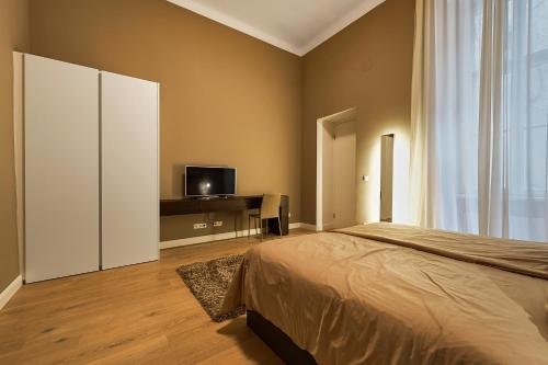 a bedroom with a bed and a flat screen tv at Central Luxury Apartment in Vienna