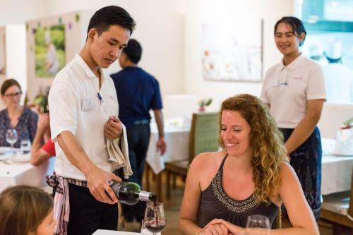 a man pouring a woman a glass of wine at Pimali Resort & Training Centre in Nong Khai