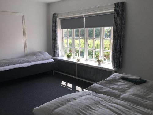 a bedroom with two beds and a window at Bed & Breakfast v/Pia Sørensen in Fredericia