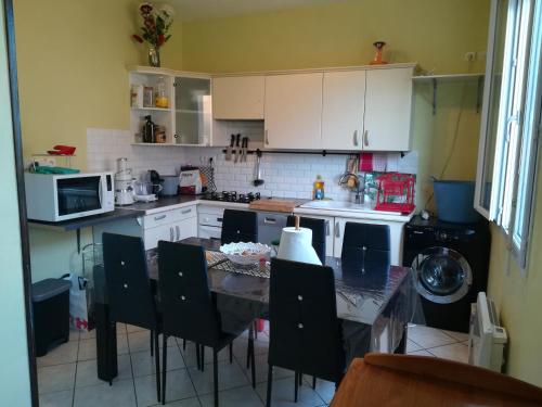 a kitchen with a table and chairs in a kitchen at Peace in Corbeil-Essonnes