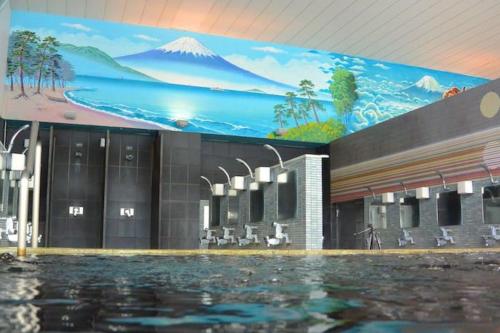 a large swimming pool with a mountain mural on the wall at Julian home Shinagawa 5 mins Shibuya 7 mins in Tokyo