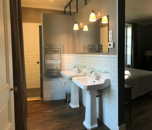 a bathroom with two sinks and a bed at COLIVAULT in Candé-sur-Beuvron
