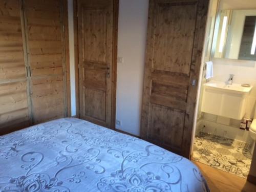 - une chambre avec un lit bleu et des portes en bois dans l'établissement Luxury Apartment, 350m to ski lift, south facing, close to town centre, à Morzine