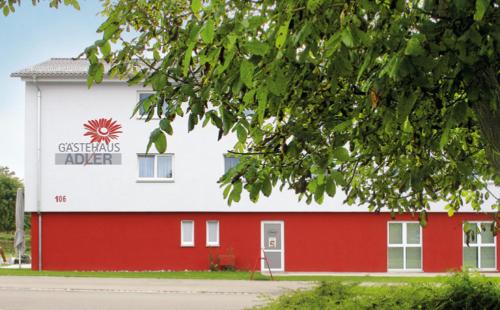 a red and white building with a sign on it at Gästehaus Adler in Biberach an der Riß
