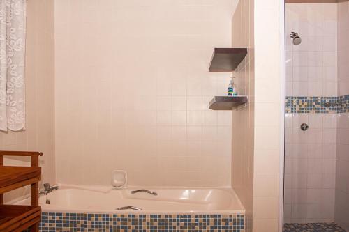 a bathroom with a bath tub and a shower at Rots en See in Gansbaai