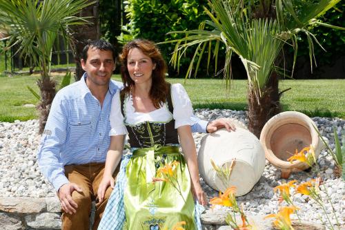 a man and a woman sitting in a garden at Hotel Nocturnes in Naturno