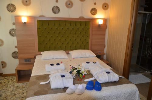a bedroom with a bed with towels and shoes on it at Lounge Hotel in Tuzla
