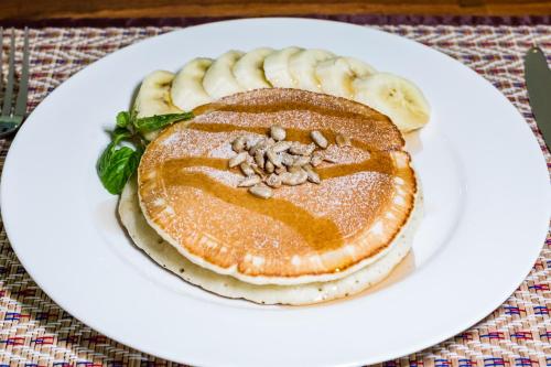 a white plate with pancakes with bananas and nuts at Pimali Resort & Training Centre in Nong Khai