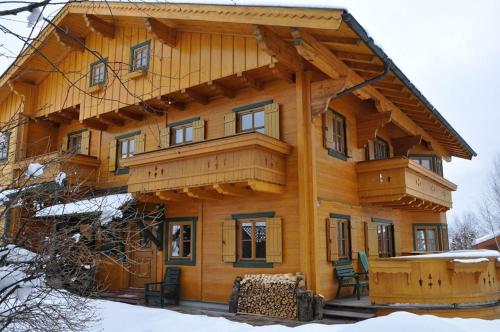 ein großes Holzhaus im Schnee in der Unterkunft Landhaus Lisa in Schladming