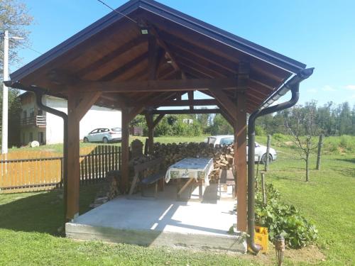 a wooden pavilion with a picnic table in a park at Holiday Apartman Ravna Dolina in Cetingrad