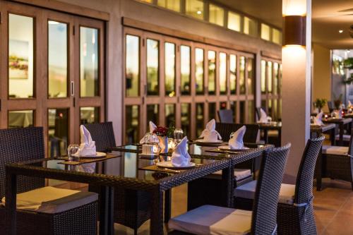 a dining room with tables and chairs with napkins on them at Pimali Resort & Training Centre in Nong Khai