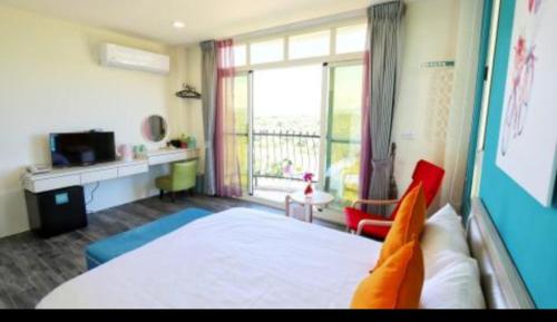 a bedroom with a bed and a large window at Full Moon Resort in Hengchun
