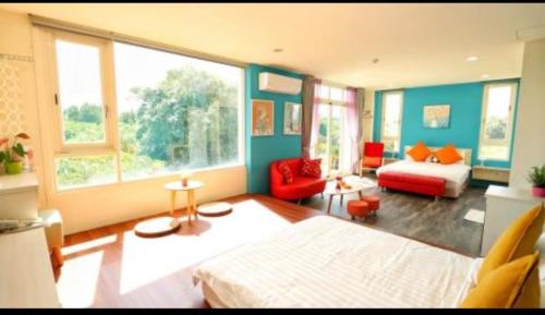 a bedroom with a bed and a couch and windows at Full Moon Resort in Hengchun