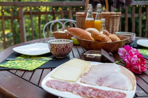 a table with a plate of cheese and bread on it at Les Cabanes du Beau Vallon in Profondeville