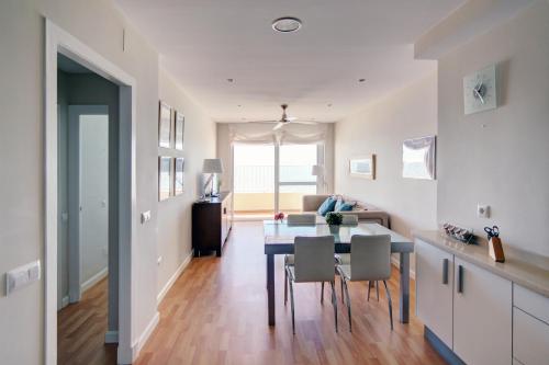 - une cuisine et une salle à manger avec une table et des chaises dans l'établissement Apartamento Playa Victoria Cadiz, à Cadix