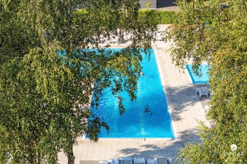 an overhead view of a swimming pool with a person in the water at Jantar Apartamenty - Family Vacation Polanki in Kołobrzeg