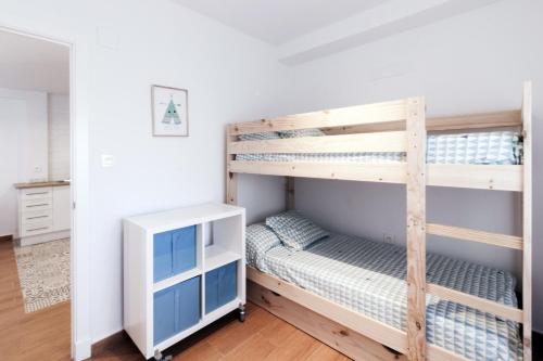sypialnia z 2 łóżkami piętrowymi i biurkiem w obiekcie Apartamento La Terraza del Mar w Kadyksie