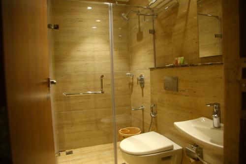 a bathroom with a shower with a toilet and a sink at Mount Manor in Chennai