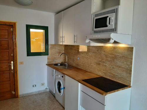 a kitchen with a sink and a microwave at Apartamento en Caleta Paraíso. in Costa de Antigua