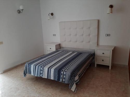 a bedroom with a bed and two night stands at Apartamento en Caleta Paraíso. in Costa de Antigua