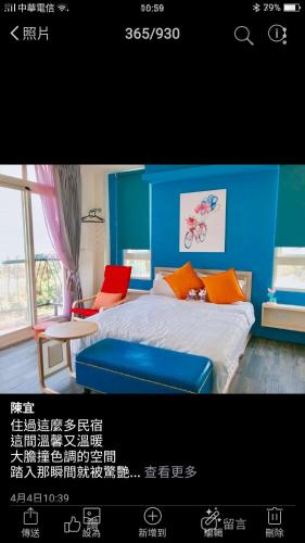 a bedroom with blue walls and a bed with orange pillows at Full Moon Resort in Hengchun
