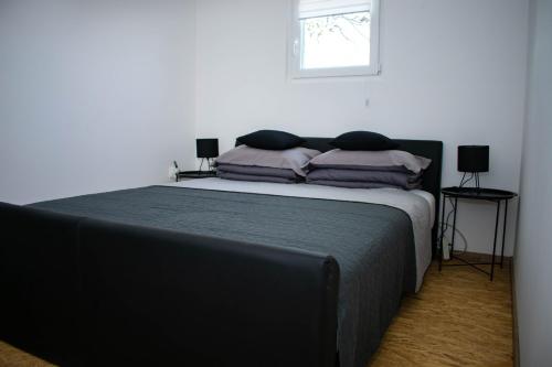 a bedroom with a bed with purple pillows and a window at OPG Dokić in Kopačevo