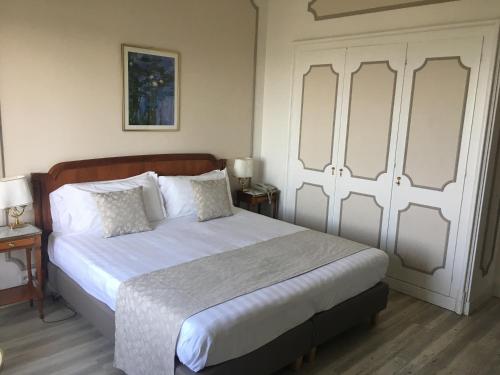 a bedroom with a large bed with white sheets at Palace Grand Hotel Varese in Varese