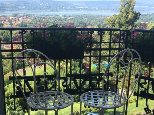 two chairs sitting on top of a balcony with a view at Palace Grand Hotel Varese in Varese