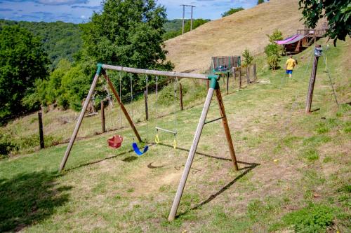 a group of swings in a field on a hill at La Ferme du Cayla in Linac