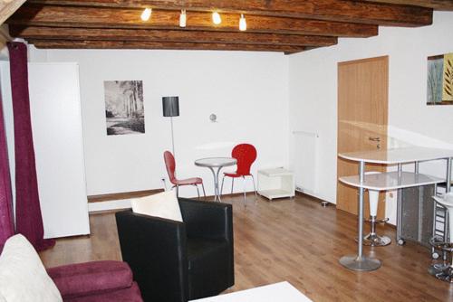 uma sala de estar com duas mesas e cadeiras vermelhas em Hermann's Neue Post em Calw