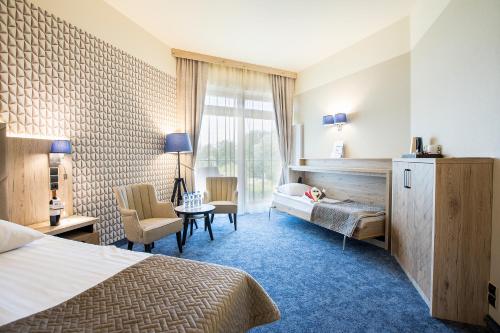 Spa & Wellness Hotel Diament Ustroń في أوسترون: غرفة في الفندق مع سرير ومكتب