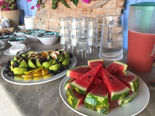 two plates of fruit on a table with a drink at Giardino Di Sicilia in SantʼAgata di Militello