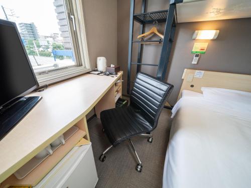 a bedroom with a desk and a bed and a chair at Super Hotel Fuji Inter in Fuji