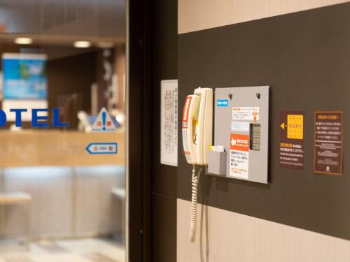 a telephone on a wall in a room at Super Hotel Fuji Inter in Fuji