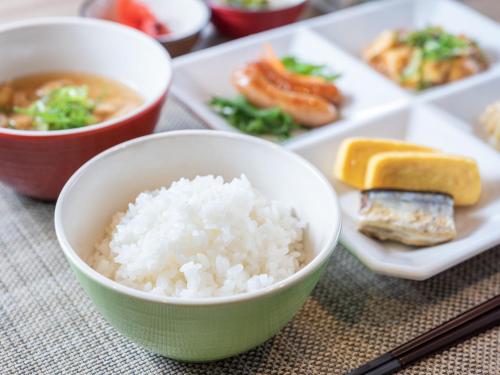 a table with a bowl of rice and a plate of food at Super Hotel Fuji Inter in Fuji