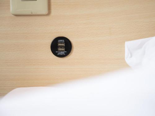 a black button is on a wooden table at Super Hotel Fuji Inter in Fuji