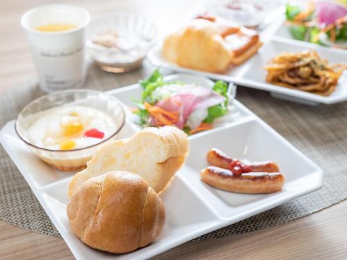 a white plate with breakfast foods on a table at Super Hotel Fuji Inter in Fuji