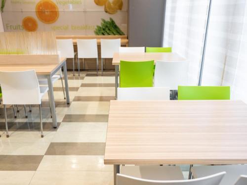 a dining room with tables and white chairs at Super Hotel Fuji Inter in Fuji