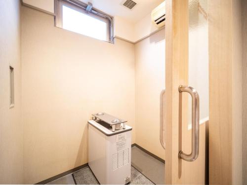 a bathroom with a toilet with a window at Super Hotel Fuji Inter in Fuji