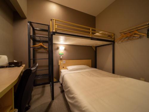a bedroom with two bunk beds and a desk at Super Hotel Fuji Inter in Fuji