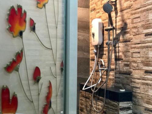 a bathroom with a shower with a phone on a wall at Ruankaew Boutique Resort Lampang in Lampang