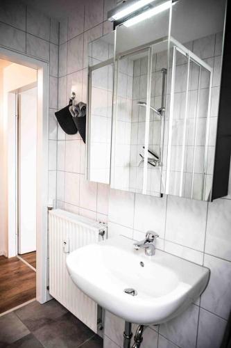 a bathroom with a white sink and a mirror at FeWo Waldblick in Meschede